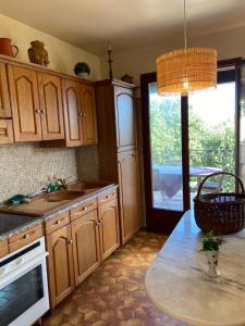 cocina con armarios de madera y encimera en Seaview Garden Villa en LʼÎle-Rousse