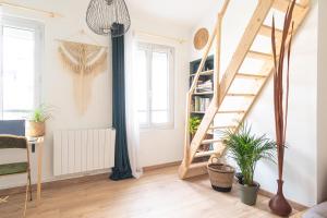 a living room with a spiral staircase and plants at La maison bohème in Le Havre