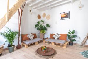 a living room with couches and potted plants at La maison bohème in Le Havre