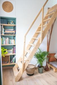 a wooden staircase in a living room with bookshelves at La maison bohème in Le Havre