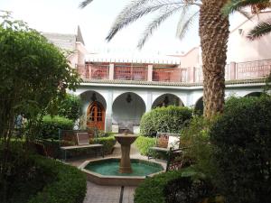 a courtyard with a fountain in front of a building at Riad Dar Hajra in Taroudant