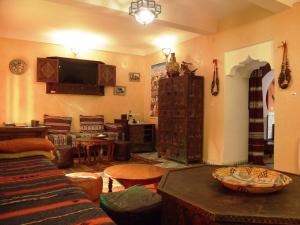 a living room with a couch and a tv at Riad Dar Hajra in Taroudant
