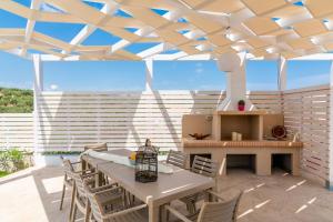 a patio with a table and chairs under a roof at Spartakos Luxury Villa 4 in Plános