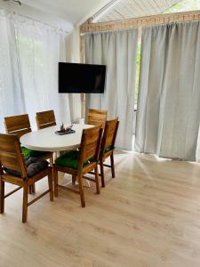 ein Esszimmer mit einem Tisch und Stühlen sowie einem TV in der Unterkunft Premium-Ferienhaus - Extertal-Ferienpark #49 in Extertal