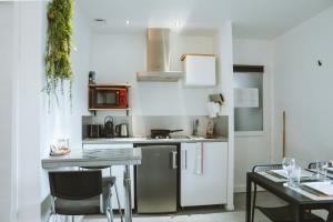 a small kitchen with a counter and a table at -WOOD- Appartement meublé cosy & confort-Parking privé & jardin in Laveyron