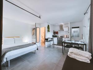 a bedroom with a bed and a table and a kitchen at -WOOD- Appartement meublé cosy & confort-Parking privé & jardin in Laveyron