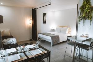 una camera d'albergo con letto, tavolo e sedie di -WOOD- Appartement meublé cosy & confort-Parking privé & jardin a Laveyron