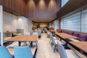 a dining room with wooden tables and chairs at Hotel GrandConsort Naha in Naha