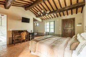 a bedroom with a large bed and a desk at Agriturismo Merigge Montepulciano in Montepulciano