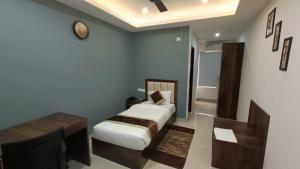 a bedroom with a bed and a desk and a table at Hotel The Classic Verna in Verna