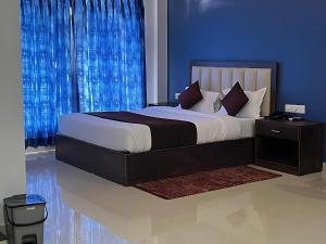 a bedroom with a large bed with blue walls at Hotel The Classic Verna in Verna