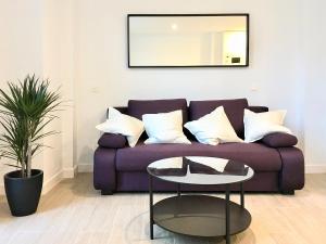un soggiorno con divano viola e tavolo di CENTRO PICACHO a Málaga