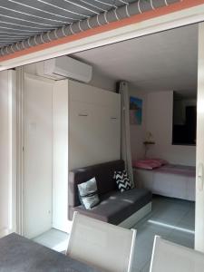 ein Wohnzimmer mit einem Sofa und einem Bett in der Unterkunft Residence Saint Clair - Studio Elena in Cap d'Agde