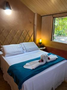 a bedroom with a bed with towels on it at Pousada Le Monte Cristo in Guaramiranga