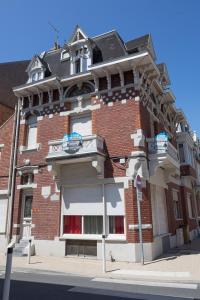un grand bâtiment en briques au coin d'une rue dans l'établissement Appartement - Villa Léopold à Malo, à Dunkerque