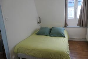 - un lit avec deux oreillers dans une chambre dotée d'une fenêtre dans l'établissement Appartement - Villa Léopold à Malo, à Dunkerque