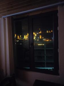 a window with a view of a city at night at Spardishi tower in Mestia