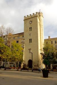 um edifício com uma torre de relógio do lado dele em LA MAISON IM em Avignon