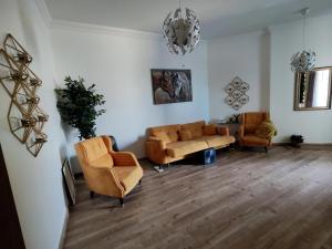 a living room with two chairs and a couch at Creekview Luxury Apartment in Ajman 