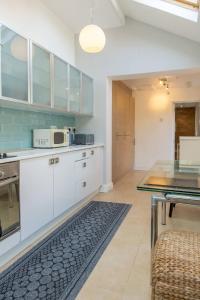 a kitchen with white cabinets and a glass table at Spacious 5 Bedroom House in Birmingham close to NEC For 12 Guests in Birmingham