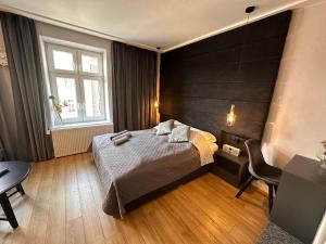 a bedroom with a bed and a desk and a window at DK Premium Mendelsohna in Olsztyn