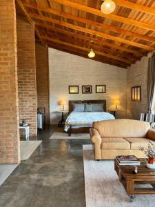 a living room with a bed and a couch at Clorofila Hospedaria in São Bento do Sapucaí