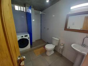 ein Badezimmer mit Waschmaschine und Toilette in der Unterkunft Casa de Orion in Ayangue