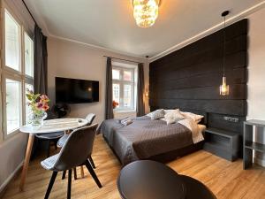 sypialnia z łóżkiem, stołem i telewizorem w obiekcie DK Premium Mendelsohna w Olsztynie