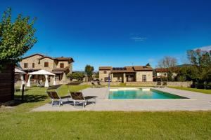 Un patio trasero con piscina y una casa. en Villa Castaldo, en Castiglion Fiorentino