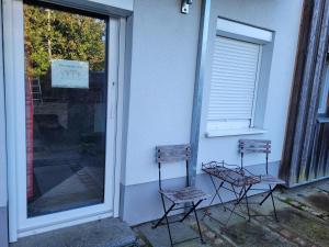 dos sillas sentadas fuera de un edificio junto a una ventana en Ferienwohnung am Minoritenhof, en Sinzing
