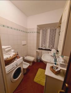 a bathroom with a toilet a sink and a washing machine at Il Borgo di Ra in San Salvatore +36 photos