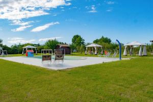 un parque con un área de juegos con sillas y un tobogán en Villa Castaldo, en Castiglion Fiorentino