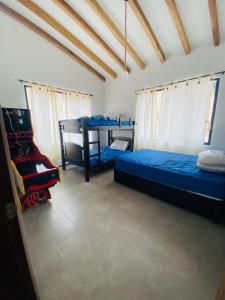 sypialnia z 2 łóżkami i krzesłem w obiekcie San Gil Villa 48 Palmaire w mieście San Gil