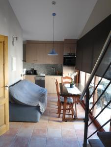 a kitchen and dining room with a table and a bed at Apartament casa Rural Cal Xico d'Adrall -La Seu d'Urgell-Andorra in Adrall