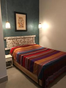1 dormitorio con 1 cama con una manta colorida en Suites Terrasol, en Ilhabela