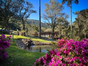 Un jardín con flores delante de un edificio. en Pousada suite avencal, en Urubici