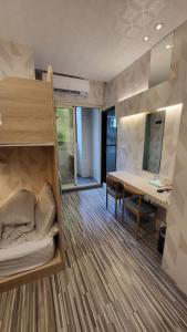 a room with a bunk bed and a desk and a table at 寓旅宿 Apato Cityhome in Kaohsiung