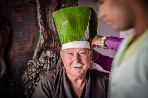 un hombre mayor con un sombrero verde en la cabeza en Ayurveda Paradise Maho, en Yapahuwa