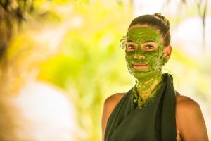 een vrouw met een gezicht bedekt met groene modder bij Ayurveda Paradise Maho in Yapahuwa
