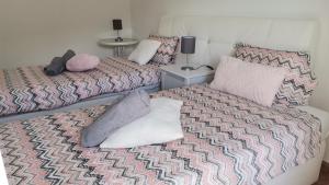 a bedroom with two beds with pillows on them at Apartamentos Guiomar Campos in Porto Covo