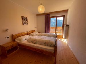 a bedroom with a bed with a window and a bed sidx sidx sidx at Ciasa de Zeno in La Valle