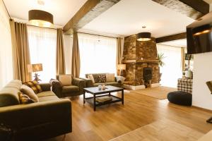 sala de estar con sofá y chimenea en The Lazy Bear, en Sovata