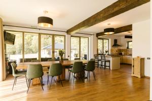 eine Küche und ein Esszimmer mit einem großen Holztisch und Stühlen in der Unterkunft The Lazy Bear in Sovata