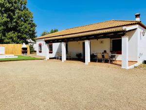 a white house with a pavilion with tables and chairs at Casa Manolín in Córdoba