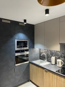 a kitchen with a sink and a microwave at Brzostek Apartment in Warsaw