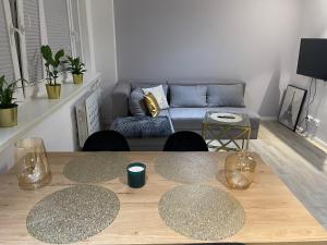 a living room with a table and a couch at Brzostek Apartamenty 1 in Warsaw