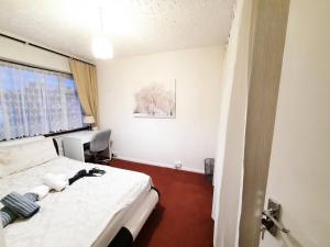 a bedroom with a bed and a desk in it at London North Downs rooms in London