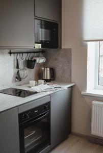 een keuken met een fornuis en een magnetron bij Rozenstein design residence in Brocēni