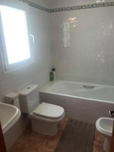 a bathroom with a toilet and a tub and a sink at VISTA SUPERIOR hola ZEEZICHT!! in Cumbre del Sol