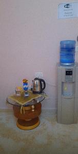 un bollitore per il tè su un tavolo accanto a un distributore d'acqua di Moon house a Wadi Musa